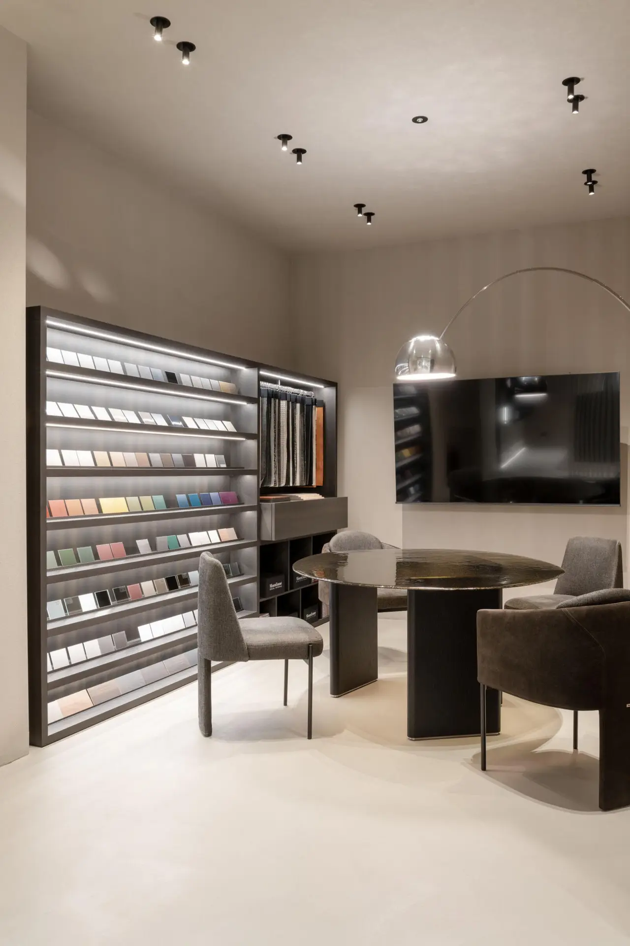 Nel flagship di Milano, la parete dei campioni di finitura accanto al tavolo di progetto