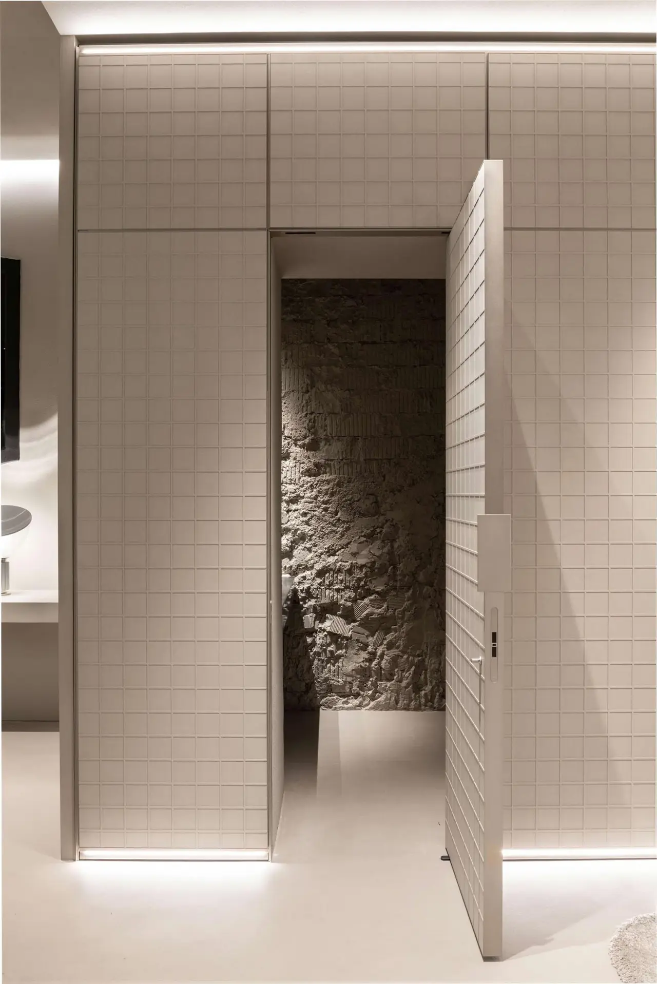 La stessa parete con la porta aperta sulla pietra grezza